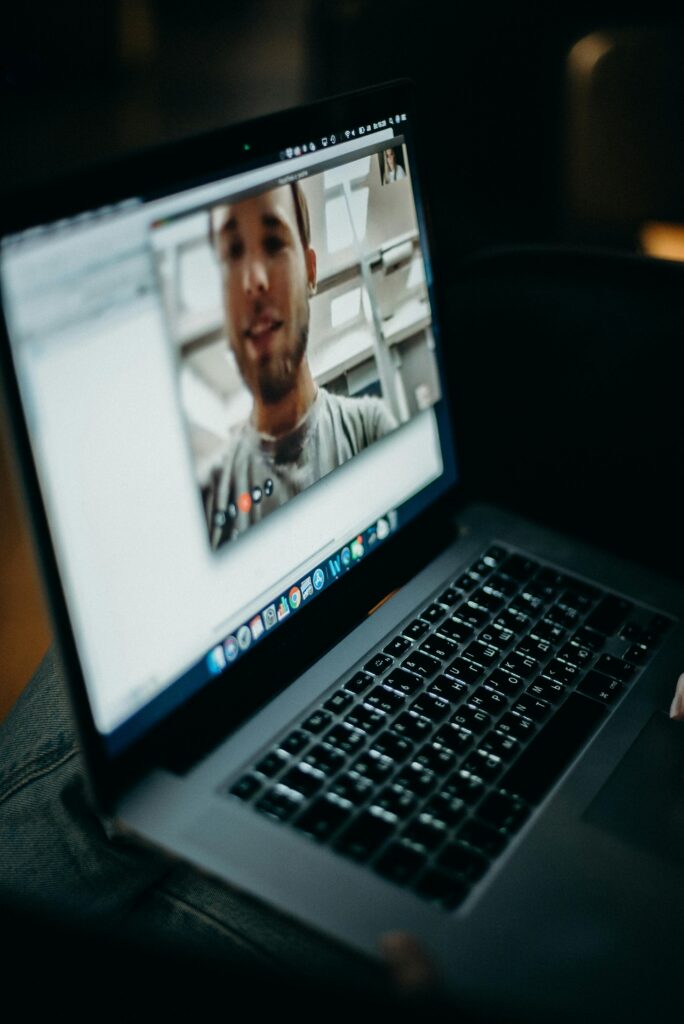 pexels-photo-3205403-3205403 Close-up of a person engaged in a video call on a laptop indoors, showcasing modern technology.